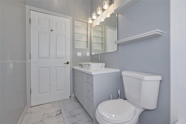 bathroom with marble finish floor, baseboards, vanity, and toilet