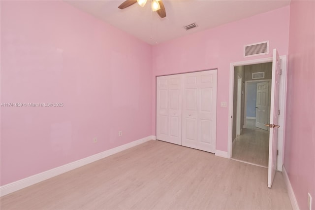 unfurnished bedroom with light wood-type flooring, a closet, visible vents, and baseboards