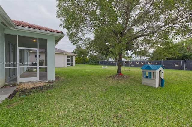 view of yard with a sunroom and fence