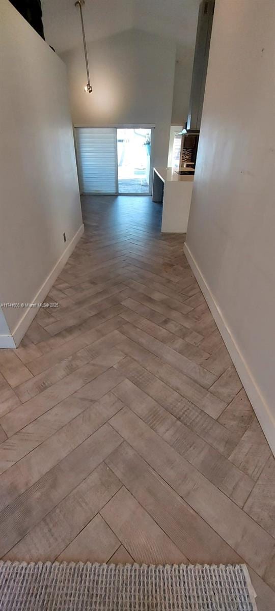 interior space with a towering ceiling and light parquet flooring