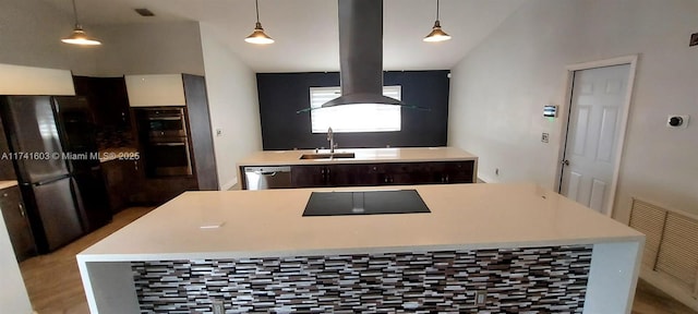 kitchen with stainless steel double oven, parquet flooring, sink, and hanging light fixtures