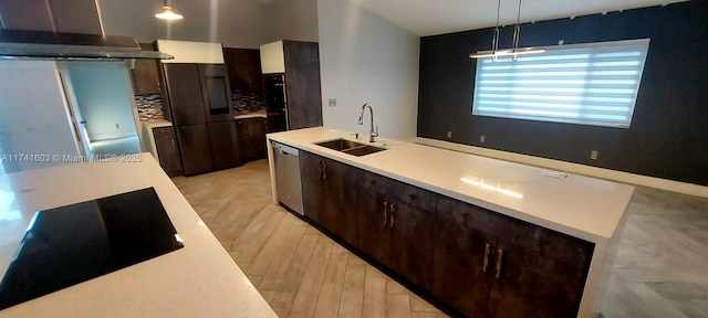 kitchen with hanging light fixtures, exhaust hood, light wood-type flooring, black electric stovetop, and sink