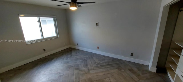 unfurnished bedroom featuring ceiling fan and dark parquet floors