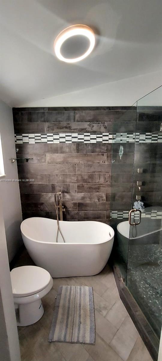 bathroom featuring an enclosed shower, toilet, tile walls, tasteful backsplash, and vanity