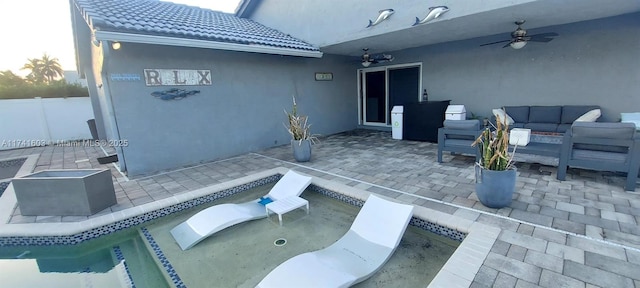 view of patio / terrace with an outdoor living space, ceiling fan, and an empty pool