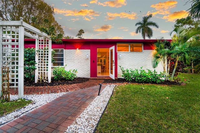 view of front of property with a yard and brick siding