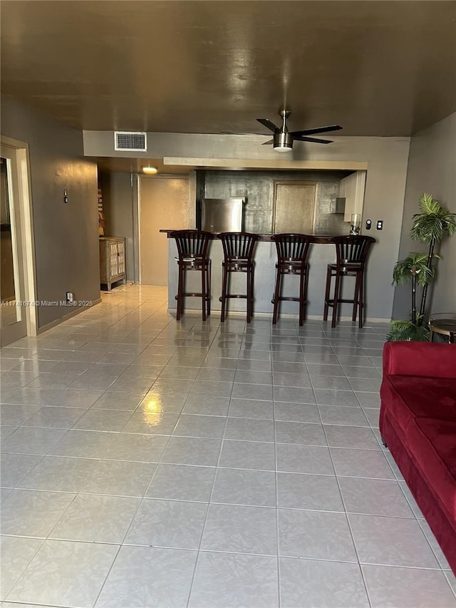 interior space with light tile patterned flooring and ceiling fan