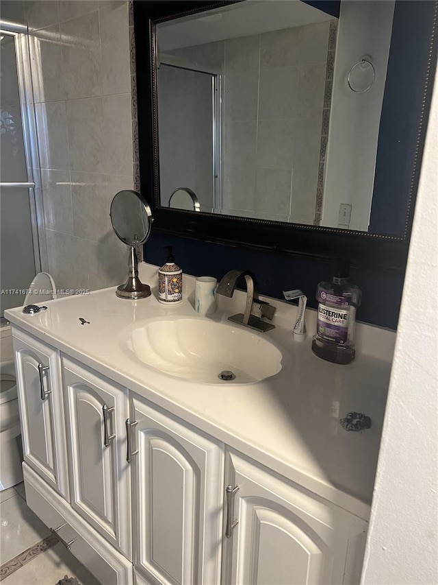 bathroom featuring tile patterned floors, vanity, toilet, and an enclosed shower