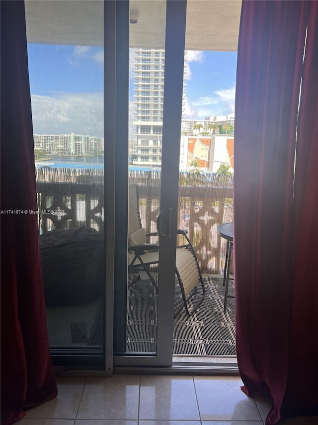 doorway featuring expansive windows, a water view, and light tile patterned flooring