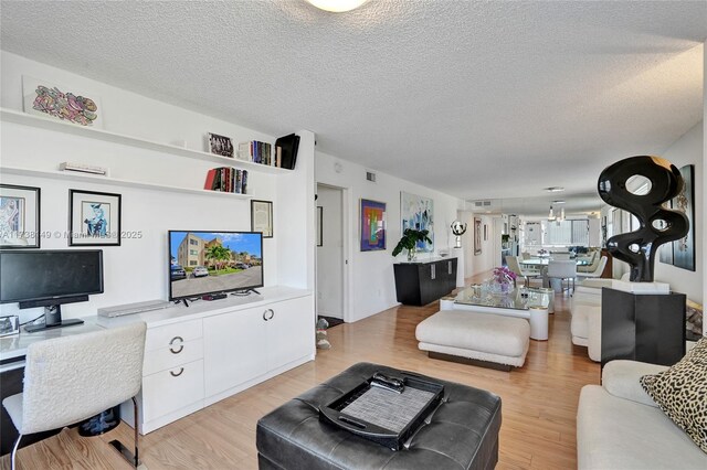 7368 Devon Dr Unit 301, Tamarac, FL 33321 - living room featuring a textured ceiling and light wood-type flooring