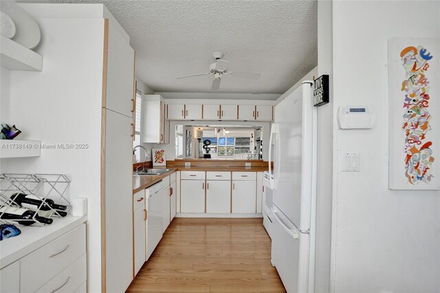 7368 Devon Dr Unit 301, Tamarac, FL 33321 - kitchen with white cabinetry, sink, white appliances, a textured ceiling, and light hardwood / wood-style flooring