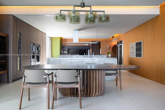 kitchen with modern cabinets, wooden walls, and a breakfast bar