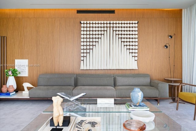 living room with carpet and wood walls