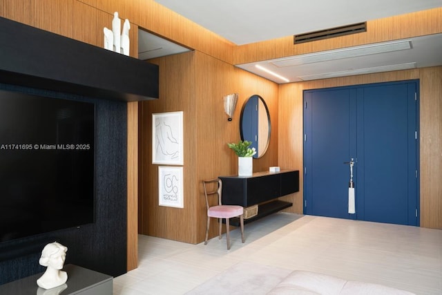 entrance foyer with visible vents and wood walls