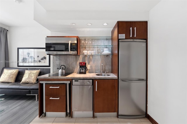 kitchen with light tile patterned floors, appliances with stainless steel finishes, sink, and backsplash