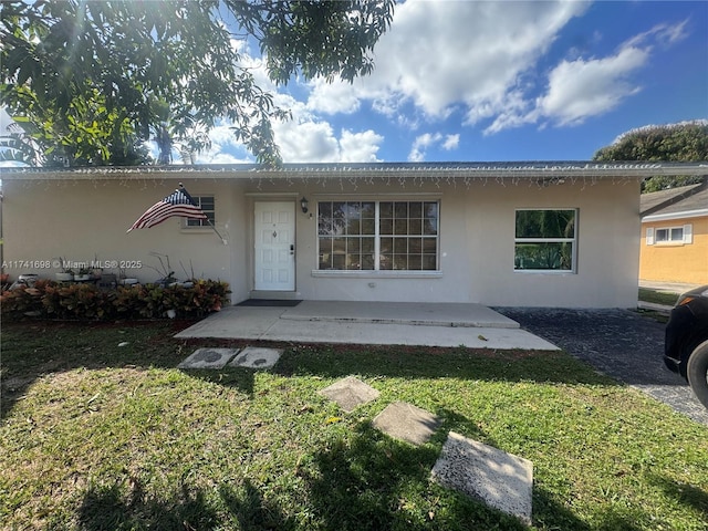 view of front of home with a patio and a front lawn