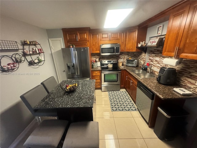 kitchen with appliances with stainless steel finishes, sink, a kitchen breakfast bar, and backsplash