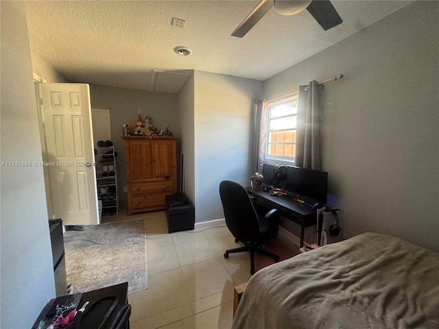 tiled bedroom featuring ceiling fan and a textured ceiling