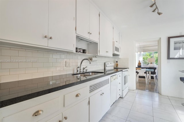 kitchen featuring white cabinetry, sink, white appliances, and backsplash