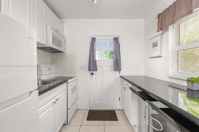 kitchen with white cabinetry, light tile patterned floors, backsplash, and white appliances