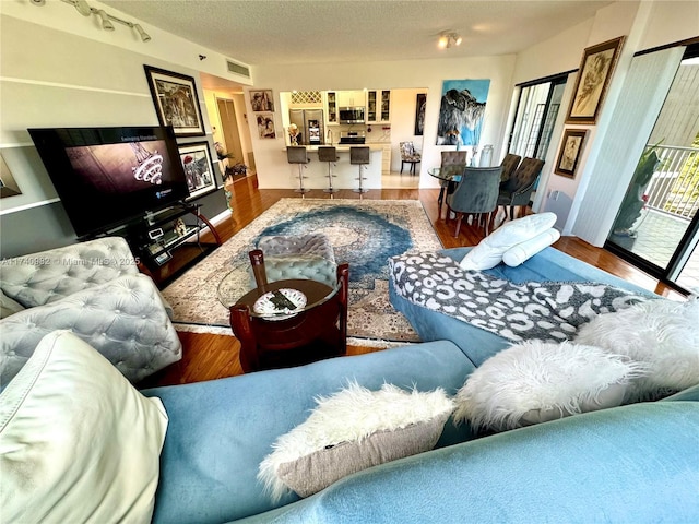 3850 Washington St Unit 317, Hollywood, FL 33021 - living room featuring hardwood / wood-style flooring, rail lighting, and a textured ceiling