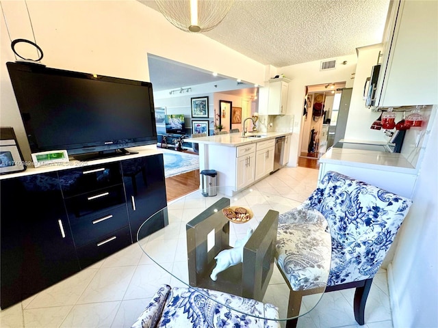 3850 Washington St Unit 317, Hollywood, FL 33021 - kitchen with sink, appliances with stainless steel finishes, white cabinetry, a textured ceiling, and kitchen peninsula