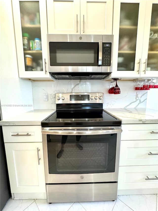 3850 Washington St Unit 317, Hollywood, FL 33021 - kitchen with stainless steel appliances, light stone countertops, and decorative backsplash
