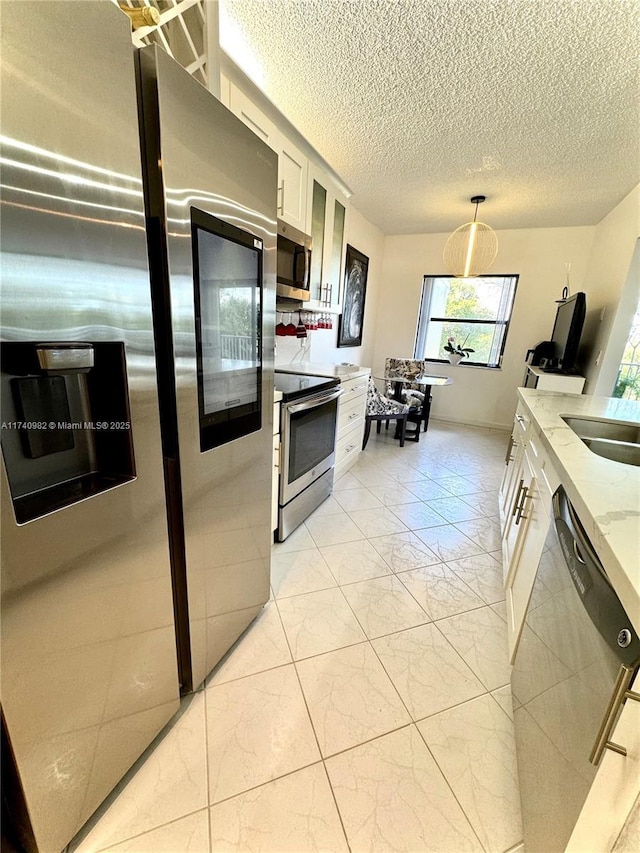 3850 Washington St Unit 317, Hollywood, FL 33021 - kitchen with pendant lighting, sink, appliances with stainless steel finishes, light stone counters, and white cabinets