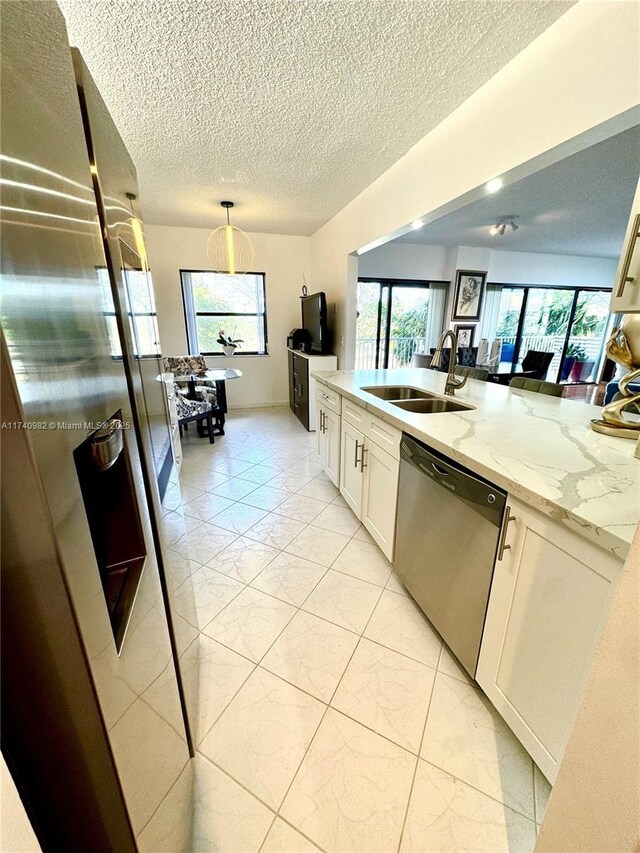 3850 Washington St Unit 317, Hollywood, FL 33021 - kitchen with decorative light fixtures, dishwasher, sink, white cabinets, and light stone counters
