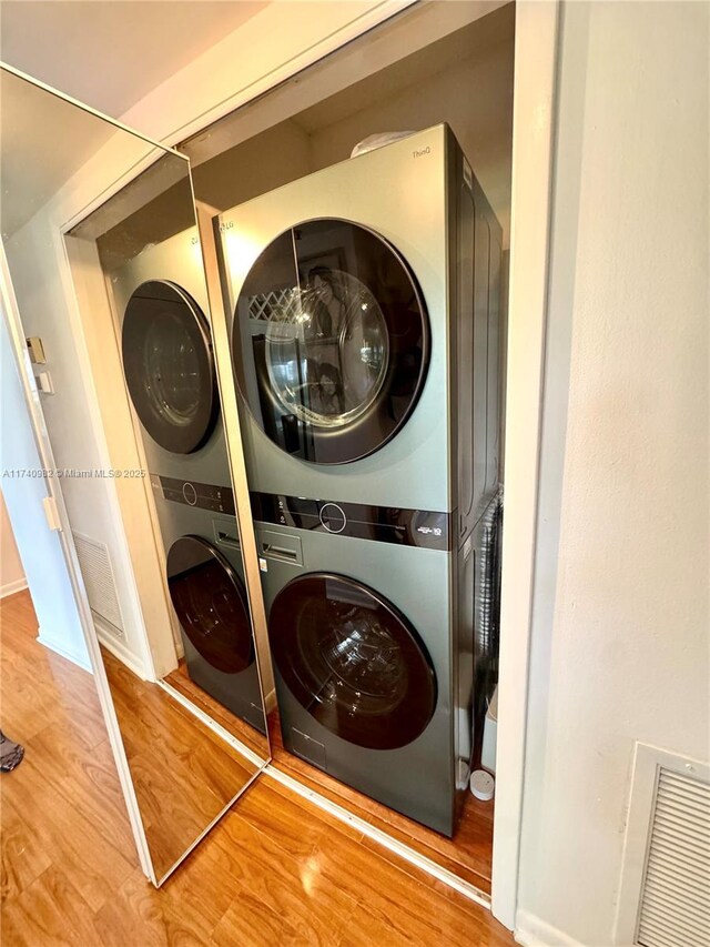 3850 Washington St Unit 317, Hollywood, FL 33021 - washroom featuring stacked washing maching and dryer and hardwood / wood-style floors