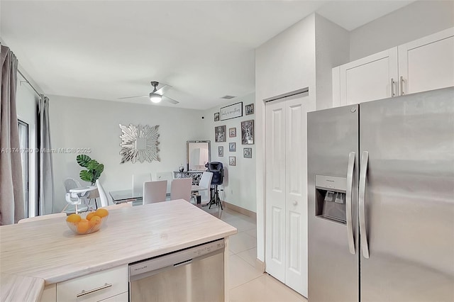 kitchen featuring light tile patterned floors, ceiling fan, white cabinets, and appliances with stainless steel finishes