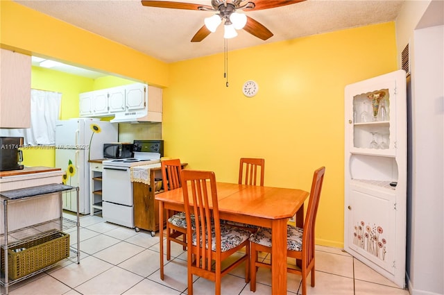 dining area with light tile patterned flooring, ceiling fan, and a textured ceiling