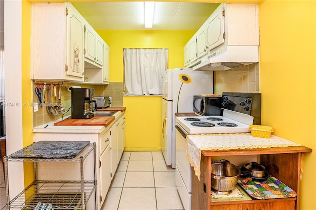 kitchen featuring white cabinetry, light tile patterned floors, decorative backsplash, and white range with electric stovetop