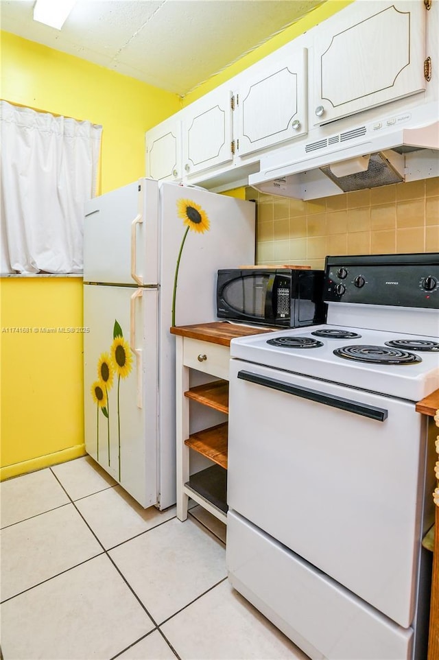 kitchen with tasteful backsplash, white appliances, light tile patterned floors, and white cabinets