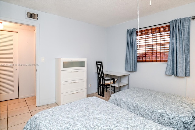 tiled bedroom with a textured ceiling