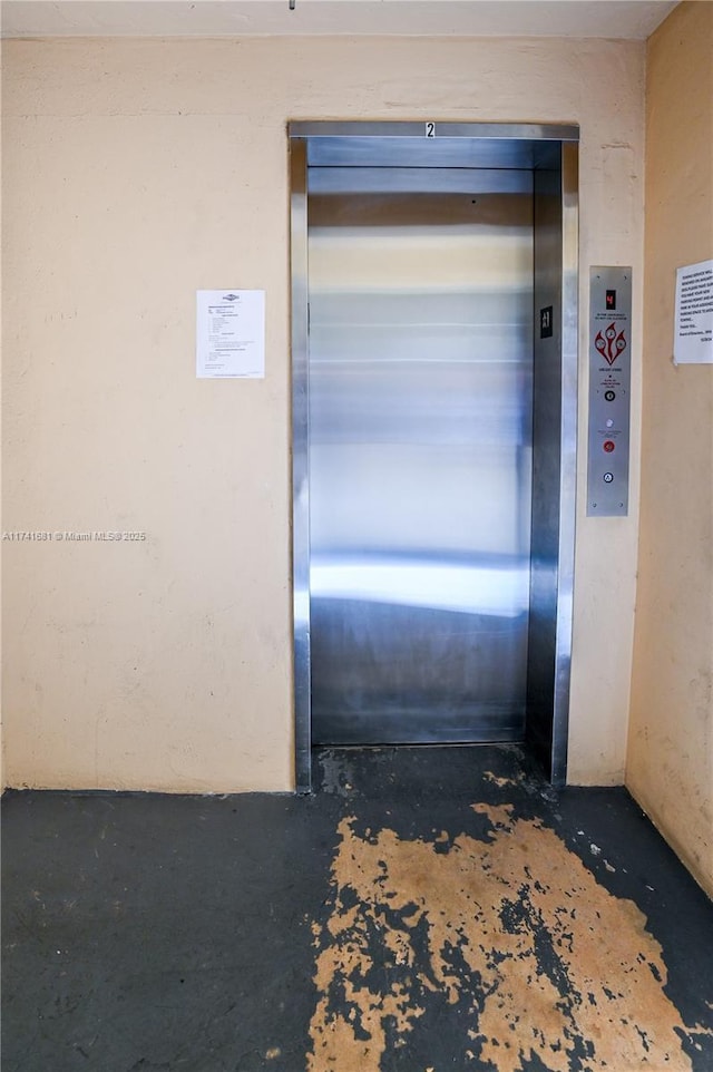 interior space featuring elevator and concrete flooring