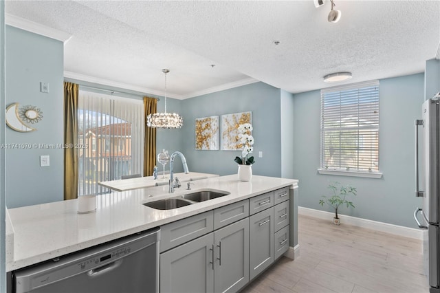 kitchen with sink, light stone counters, decorative light fixtures, light hardwood / wood-style flooring, and appliances with stainless steel finishes