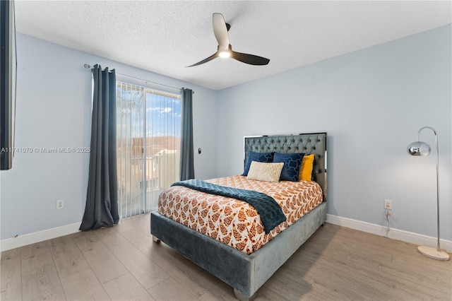 bedroom featuring ceiling fan, hardwood / wood-style floors, access to exterior, and a textured ceiling