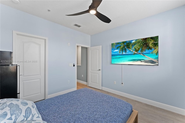 bedroom featuring stainless steel fridge and ceiling fan