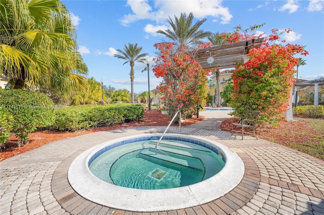 view of pool with a hot tub and a pergola