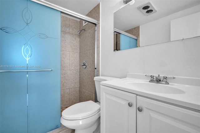 bathroom featuring vanity, a shower with shower door, and toilet