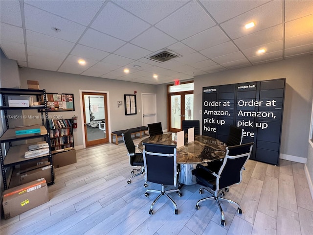 office with a paneled ceiling, french doors, and light wood-type flooring