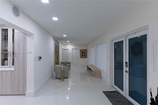 corridor featuring light tile patterned floors and french doors