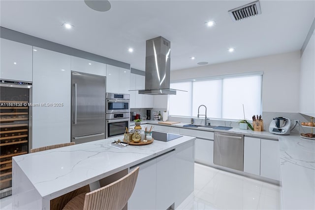 kitchen featuring white cabinetry, stainless steel appliances, a center island, wine cooler, and island exhaust hood