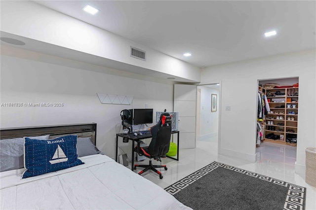 bedroom with a spacious closet and light tile patterned flooring