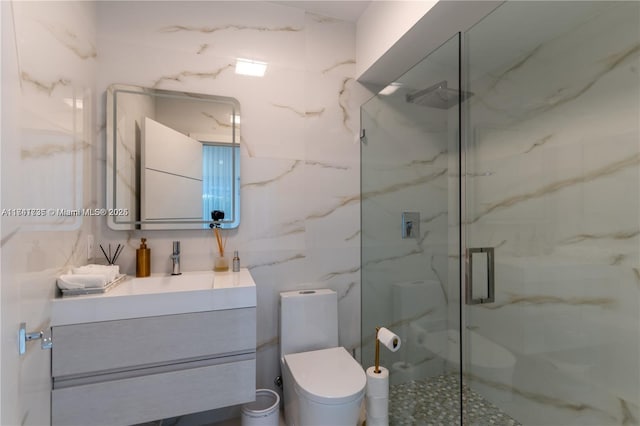 bathroom with vanity, tile walls, toilet, and walk in shower