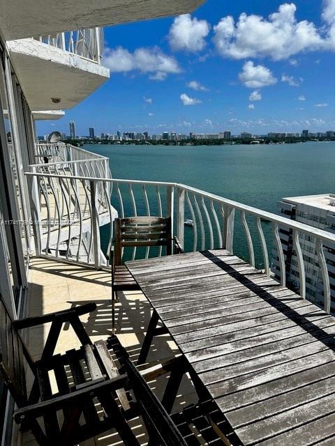 view of dock with a water view and a balcony