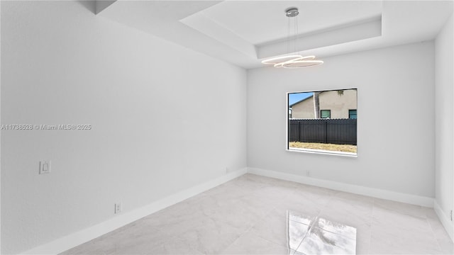 empty room featuring a raised ceiling