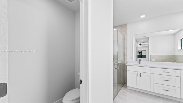 bathroom with vanity, a shower with door, and toilet