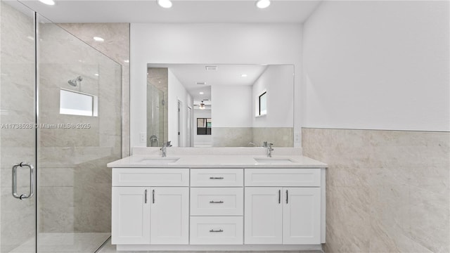 bathroom with vanity, an enclosed shower, and tile walls